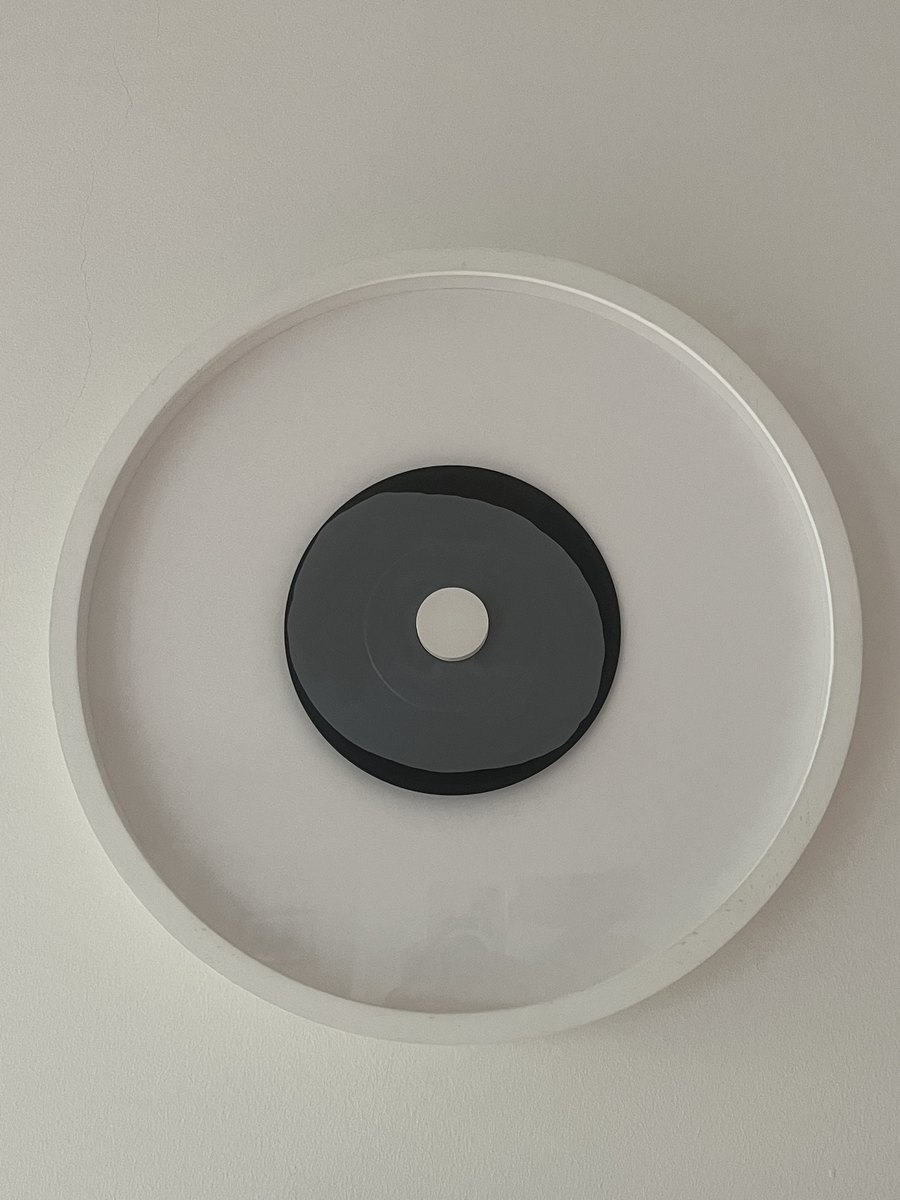Isa Genzken und Gerhard Richter, Tri-Star, 1981: kreisrundes weißes Relief mit einer dunkelgrauen Scheibe und einem kleinen weißen Punkt in der Mitte
